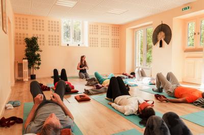 Un hélicoptère posé sur une pelouse, entouré d'arbres et de bâtiments en arrière-plan.