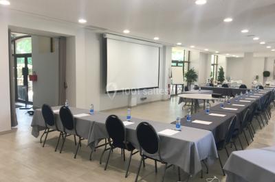 Un hélicoptère posé sur une pelouse, entouré d'arbres et de bâtiments en arrière-plan.