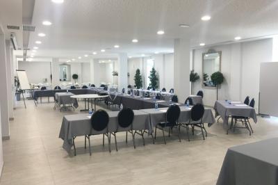 Un hélicoptère posé sur une pelouse, entouré d'arbres et de bâtiments en arrière-plan.