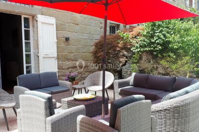 Un hélicoptère posé sur une pelouse, entouré d'arbres et de bâtiments en arrière-plan.