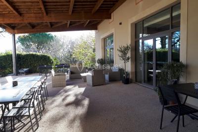 Un hélicoptère posé sur une pelouse, entouré d'arbres et de bâtiments en arrière-plan.