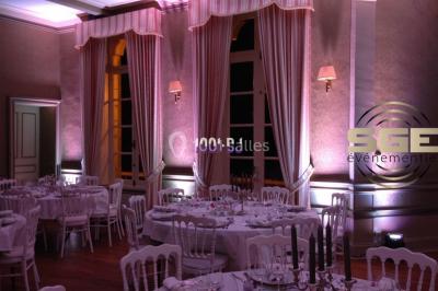 Installation de matériel de sonorisation et d'éclairage sous une tente, avec une table de mixage et des projecteurs.