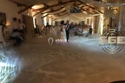 Installation de matériel de sonorisation et d'éclairage sous une tente, avec une table de mixage et des projecteurs.