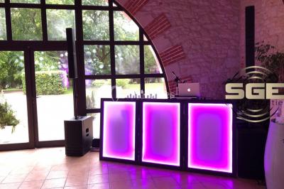 Installation de matériel de sonorisation et d'éclairage sous une tente, avec une table de mixage et des projecteurs.