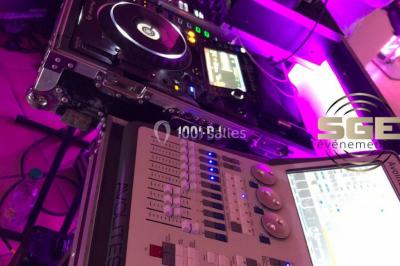 Installation de matériel de sonorisation et d'éclairage sous une tente, avec une table de mixage et des projecteurs.