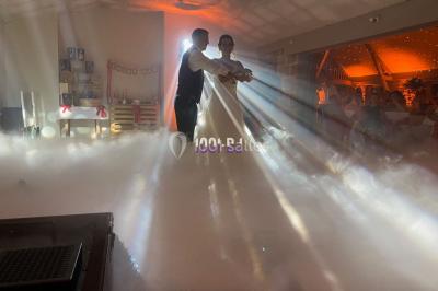 Installation de matériel de sonorisation et d'éclairage sous une tente, avec une table de mixage et des projecteurs.