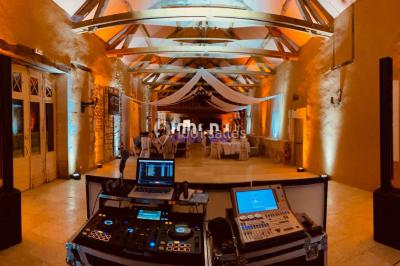 Installation de matériel de sonorisation et d'éclairage sous une tente, avec une table de mixage et des projecteurs.