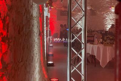 Installation de matériel de sonorisation et d'éclairage sous une tente, avec une table de mixage et des projecteurs.