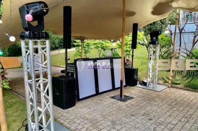 Façade en pierre éclairée par des lumières violettes, avec une porte voûtée et un sol en dalles.