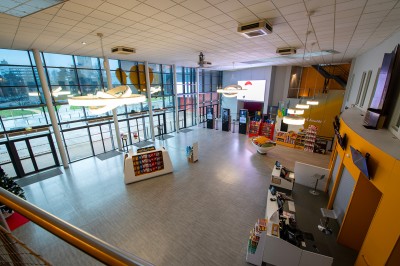 Une personne sert un verre de jus d'orange sur une table garnie de carafes, verres et viennoiseries.