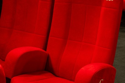 Une personne sert un verre de jus d'orange sur une table garnie de carafes, verres et viennoiseries.