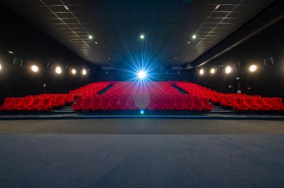 Une personne sert un verre de jus d'orange sur une table garnie de carafes, verres et viennoiseries.