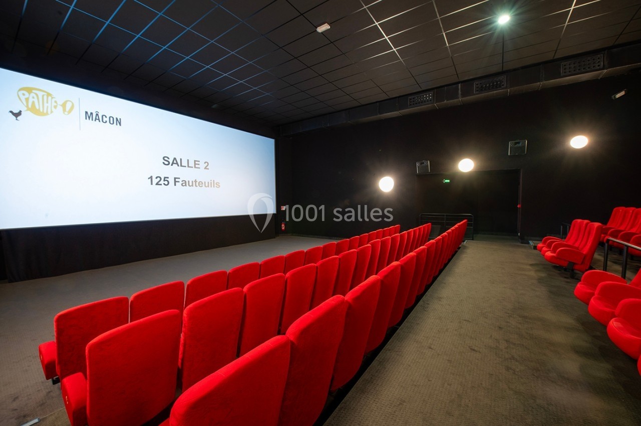 Salle de cinéma vide avec des rangées de fauteuils rouges, un écran affichant ’Salle 2 - 125 fauteuils’.