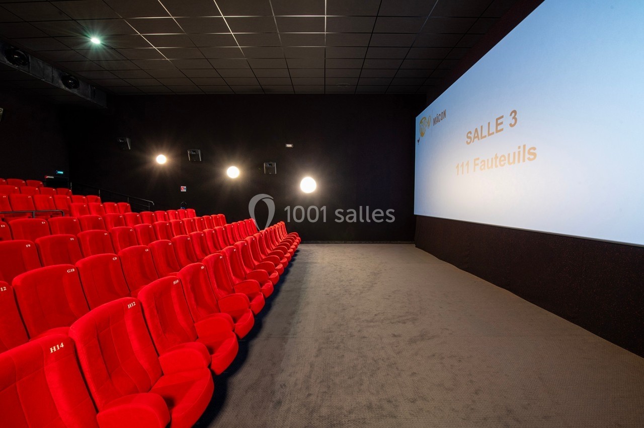 Salle de cinéma vide avec des rangées de fauteuils rouges et un écran affichant ’Salle 3 - 111 fauteuils’.