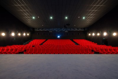 Une personne sert un verre de jus d'orange sur une table garnie de carafes, verres et viennoiseries.