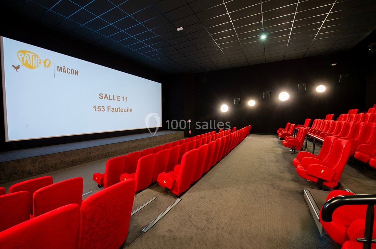 Salle de cinéma vide avec des rangées de fauteuils rouges et un écran affichant ’Salle 11 - 153 fauteuils’.