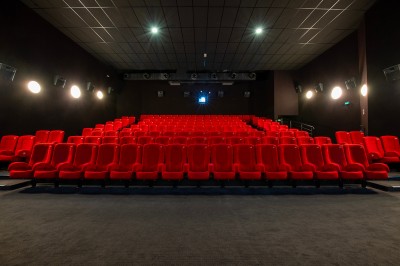 Une personne sert un verre de jus d'orange sur une table garnie de carafes, verres et viennoiseries.