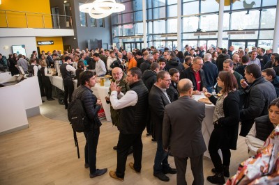 Une personne sert un verre de jus d'orange sur une table garnie de carafes, verres et viennoiseries.