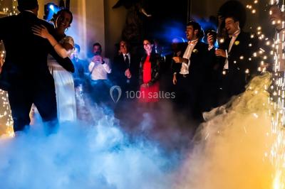 Un couple danse au milieu d'une piste entourée de fumée, tandis qu'un musicien joue du saxophone en avant-plan.