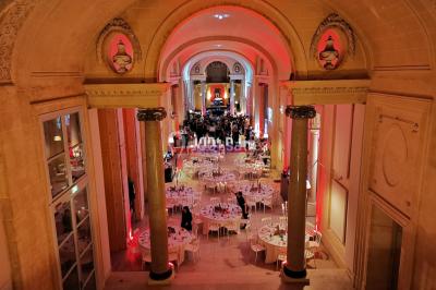Un couple danse au milieu d'une piste entourée de fumée, tandis qu'un musicien joue du saxophone en avant-plan.
