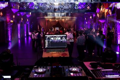Un couple danse au milieu d'une piste entourée de fumée, tandis qu'un musicien joue du saxophone en avant-plan.