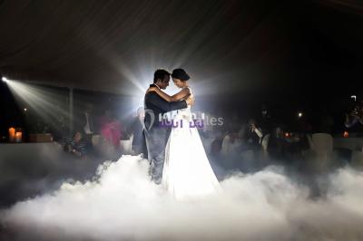Un couple danse au milieu d'une piste entourée de fumée, tandis qu'un musicien joue du saxophone en avant-plan.