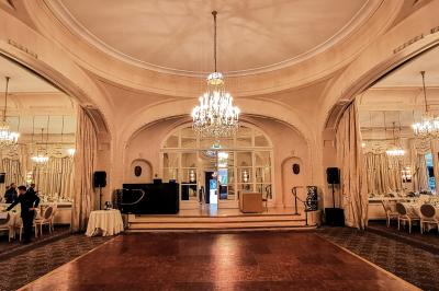 Vue d'une régie DJ avec platines et ordinateur, face à une salle éclairée en violet lors d'un événement festif.