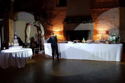 Vue d'une régie DJ avec platines et ordinateur, face à une salle éclairée en violet lors d'un événement festif.
