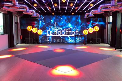 Terrasse moderne avec mobilier en rotin, plantes en pot et fresque murale représentant une skyline urbaine.