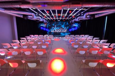 Terrasse moderne avec mobilier en rotin, plantes en pot et fresque murale représentant une skyline urbaine.