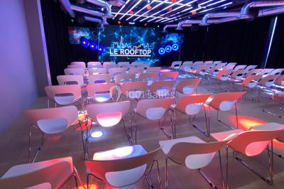 Terrasse moderne avec mobilier en rotin, plantes en pot et fresque murale représentant une skyline urbaine.