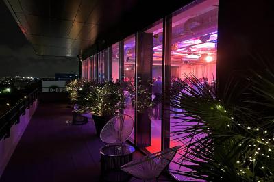 Terrasse moderne avec mobilier en rotin, plantes en pot et fresque murale représentant une skyline urbaine.