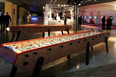 Miniature ArScénique #8 Homme sur une planche de surf simulant une vague géante gonflable dans un espace intérieur éclairé.