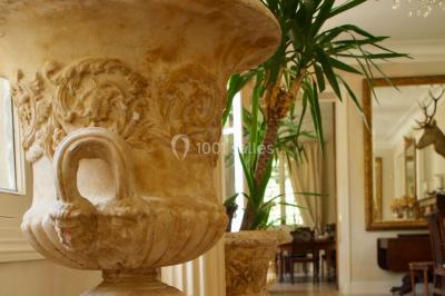 Statue en métal représentant un ange ailé allongé sur un décor ornemental aux détails sculptés.