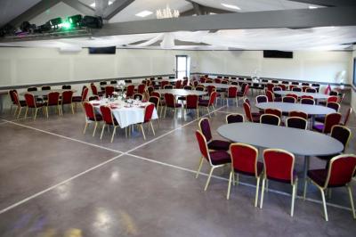Salle d'attente lumineuse avec banquettes rouges et grises, table en marbre blanc et écran mural.