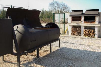 Salle d'attente lumineuse avec banquettes rouges et grises, table en marbre blanc et écran mural.