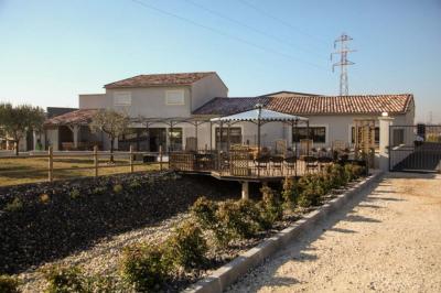 Salle d'attente lumineuse avec banquettes rouges et grises, table en marbre blanc et écran mural.