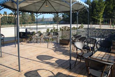 Salle d'attente lumineuse avec banquettes rouges et grises, table en marbre blanc et écran mural.