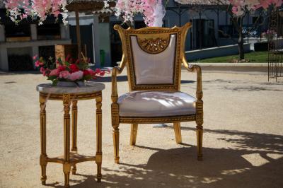 Salle d'attente lumineuse avec banquettes rouges et grises, table en marbre blanc et écran mural.