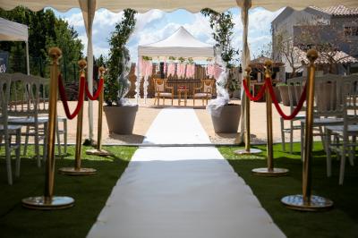 Salle d'attente lumineuse avec banquettes rouges et grises, table en marbre blanc et écran mural.