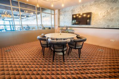 Salle de réunion avec table en bois foncé, six chaises grises, tableau blanc et écran mural.