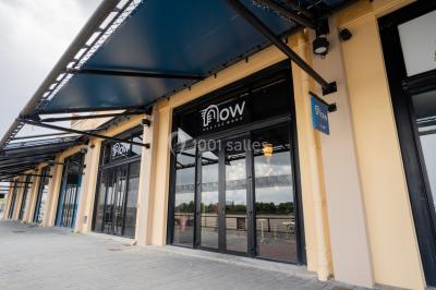 Salle de réunion avec table en bois foncé, six chaises grises, tableau blanc et écran mural.