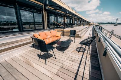 Salle de réunion avec table en bois foncé, six chaises grises, tableau blanc et écran mural.