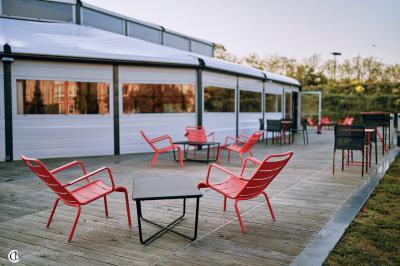Salle de réception éclairée la nuit, avec des tables dressées visibles à travers les baies vitrées.