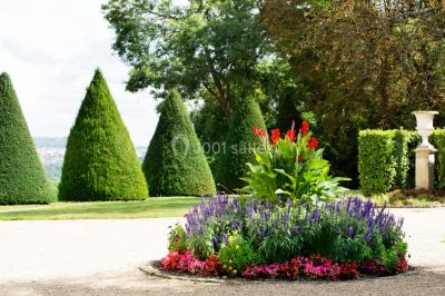 Coin cuisine moderne avec micro-ondes, cafetière, réfrigérateur, étagères en bois et horloge murale.