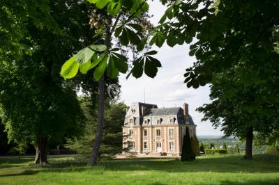 Coin cuisine moderne avec micro-ondes, cafetière, réfrigérateur, étagères en bois et horloge murale.