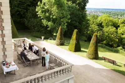 Coin cuisine moderne avec micro-ondes, cafetière, réfrigérateur, étagères en bois et horloge murale.