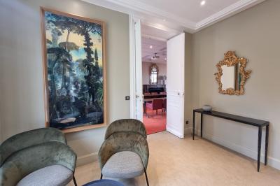 Coin cuisine moderne avec micro-ondes, cafetière, réfrigérateur, étagères en bois et horloge murale.