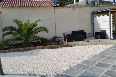 Tables rondes dressées avec nappes blanches, serviettes roses et verres, disposées en extérieur sous des parasols.