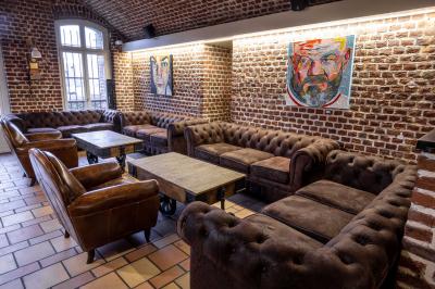 Salle de restaurant avec murs en briques, bar éclairé en arrière-plan et table dressée au premier plan.